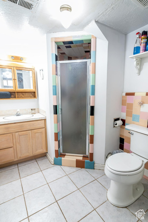 Full bath featuring toilet, visible vents, tile patterned flooring, a shower stall, and vanity