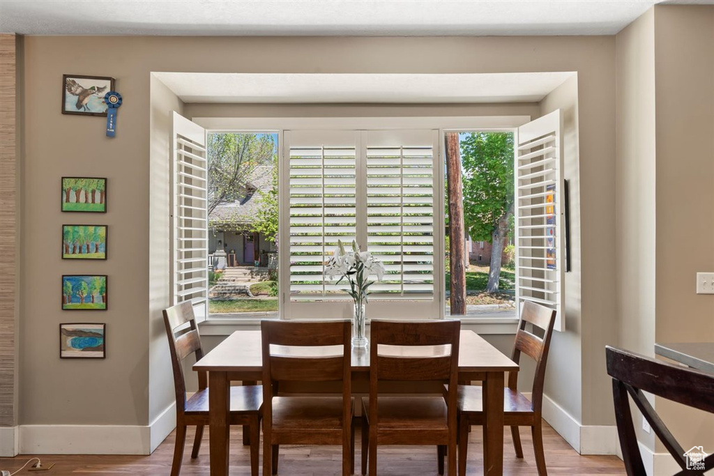 Dining area with baseboards, wood finished floors, and a wealth of natural light