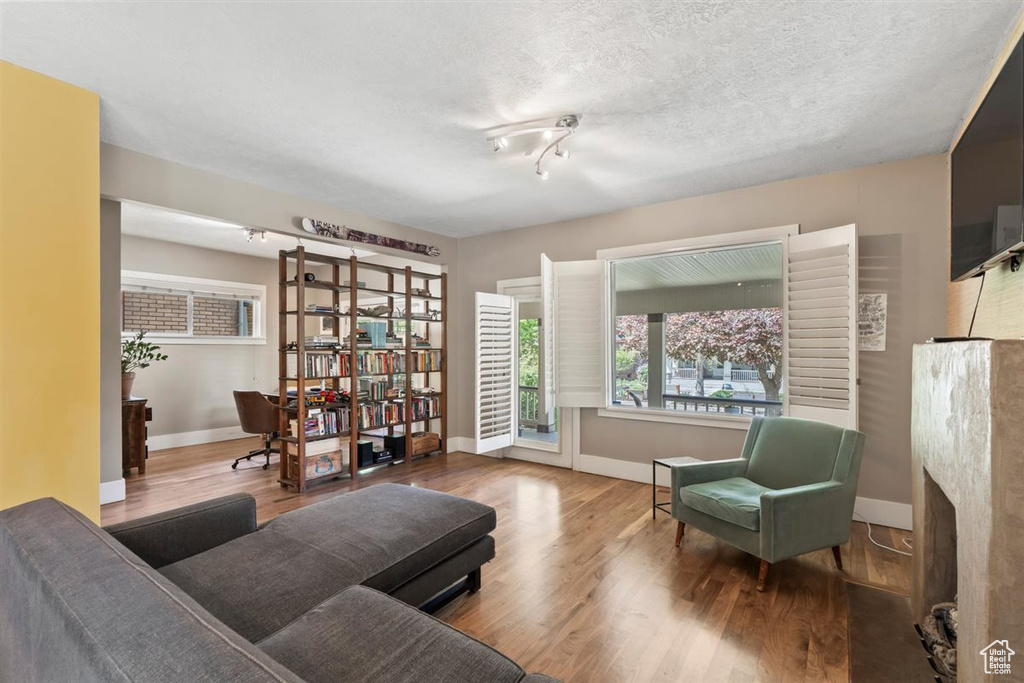 Living area with baseboards and wood finished floors