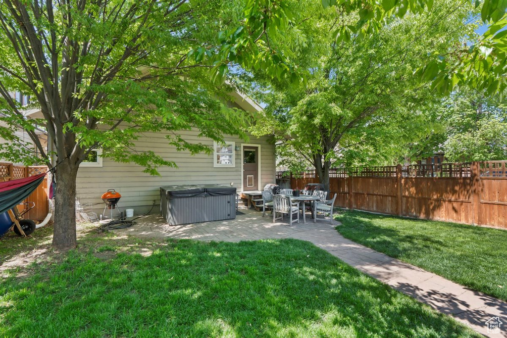 View of yard with a fenced backyard, a patio, and a hot tub