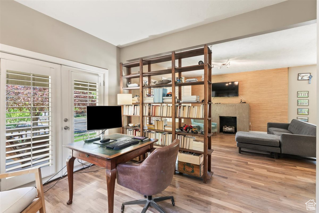 Office space featuring light wood-type flooring and a fireplace
