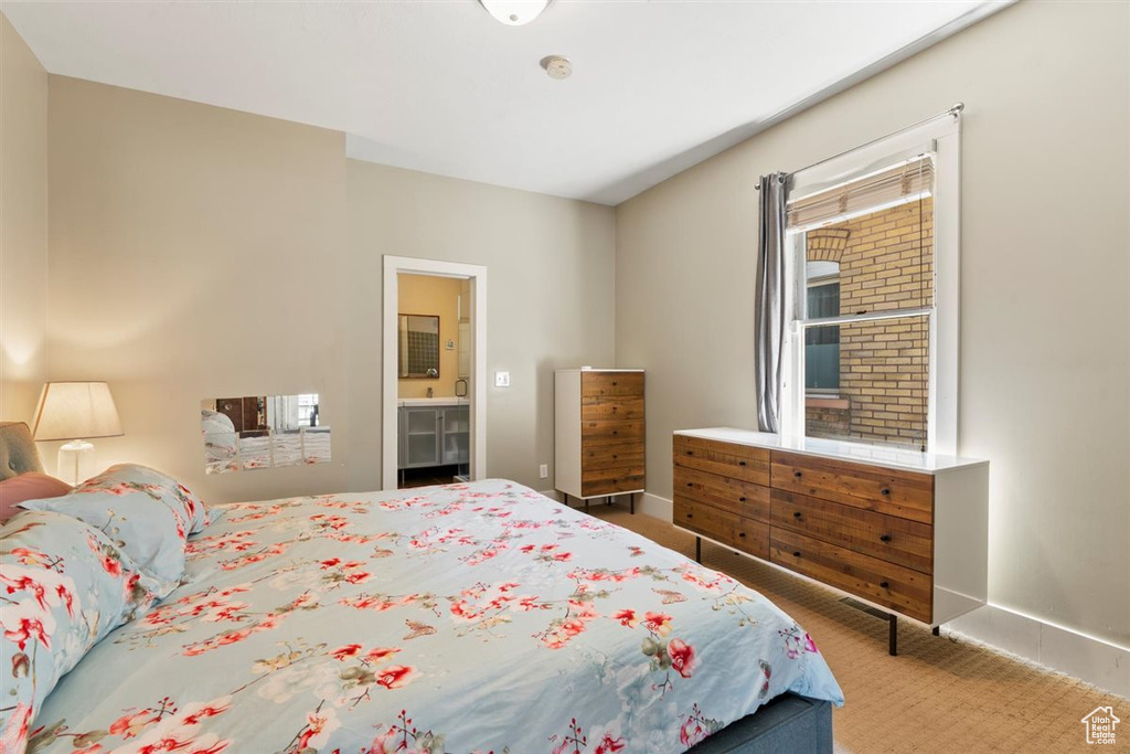 Bedroom with carpet floors, connected bathroom, and baseboards
