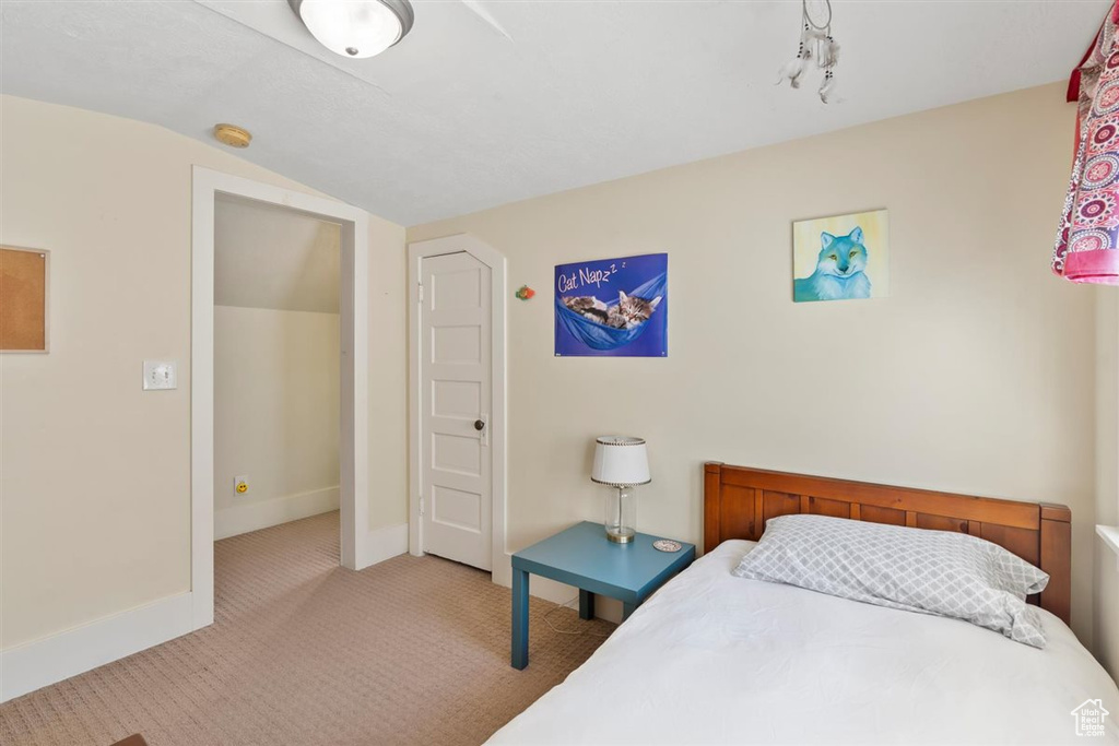 Bedroom featuring baseboards, carpet flooring, and lofted ceiling