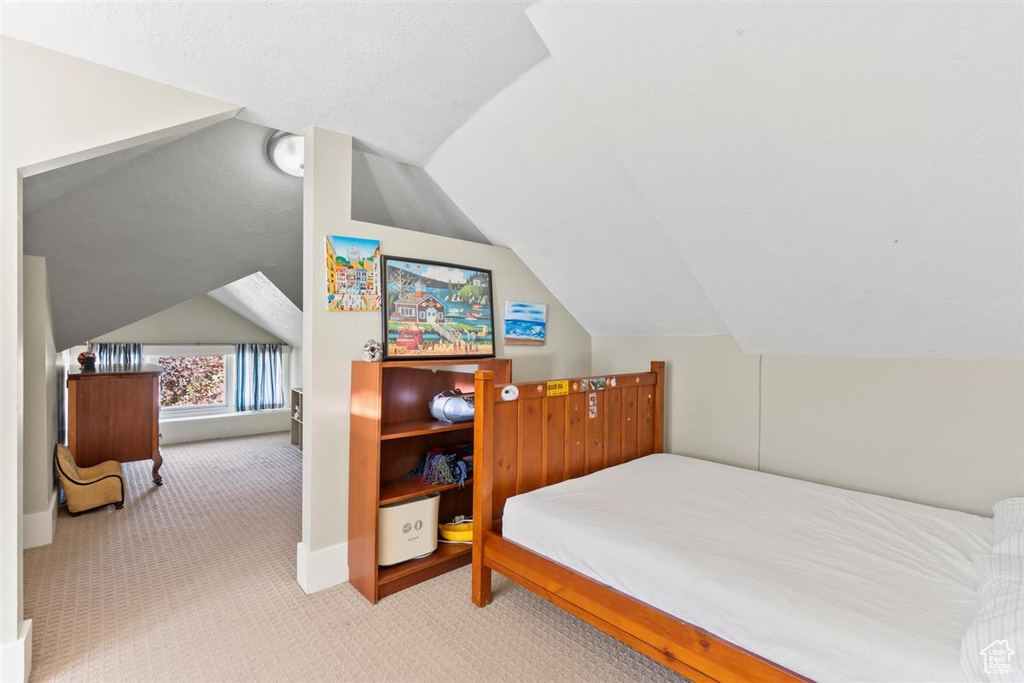 Carpeted bedroom with lofted ceiling