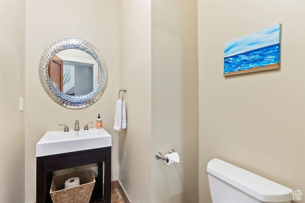 Half bathroom with baseboards, a sink, and toilet