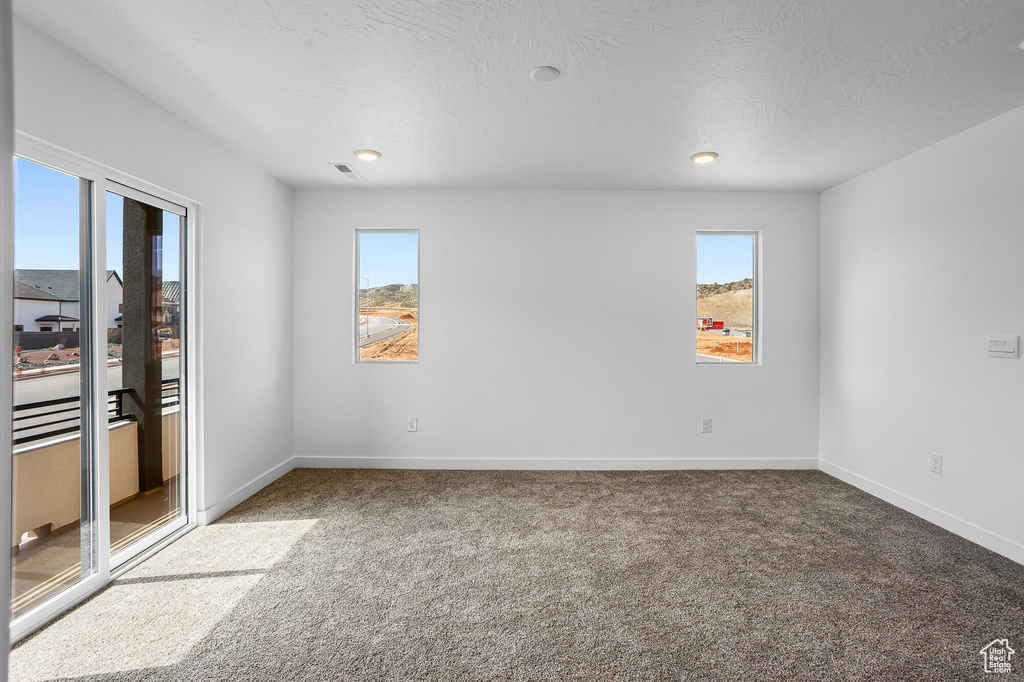 Unfurnished bedroom featuring access to exterior, carpet floors, visible vents, baseboards, and recessed lighting