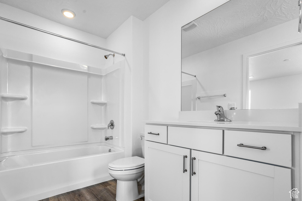Full bathroom featuring recessed lighting, toilet,  shower combination, vanity, and wood finished floors