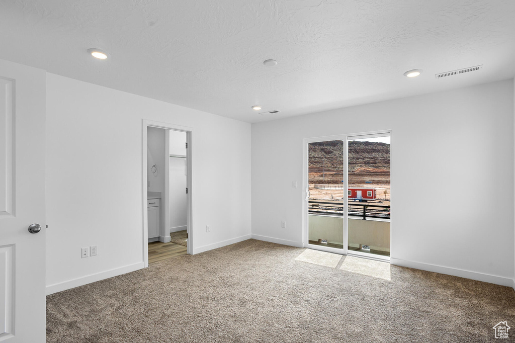 Unfurnished bedroom with recessed lighting, baseboards, carpet flooring, visible vents, and access to exterior