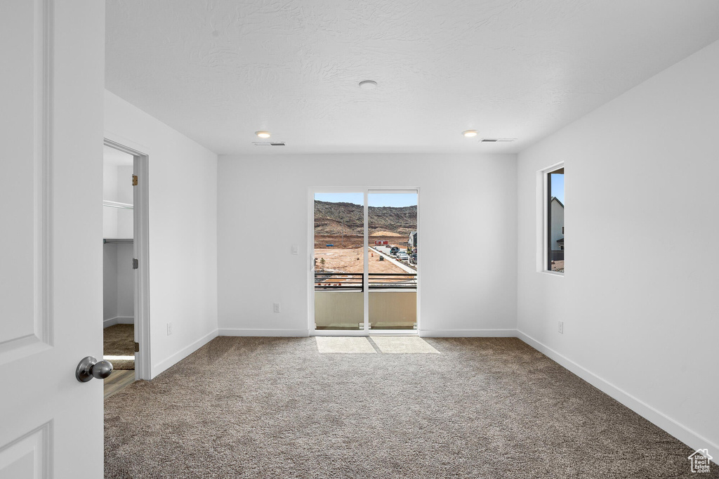 Carpeted spare room with visible vents, baseboards, and recessed lighting