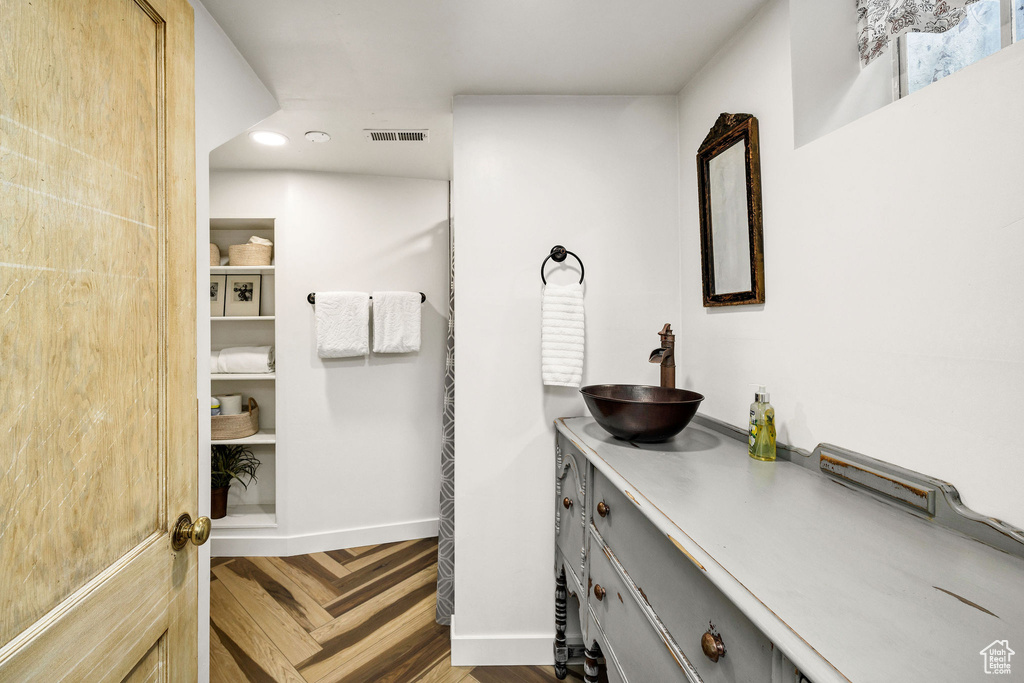 Bathroom with vanity, baseboards, visible vents, and recessed lighting