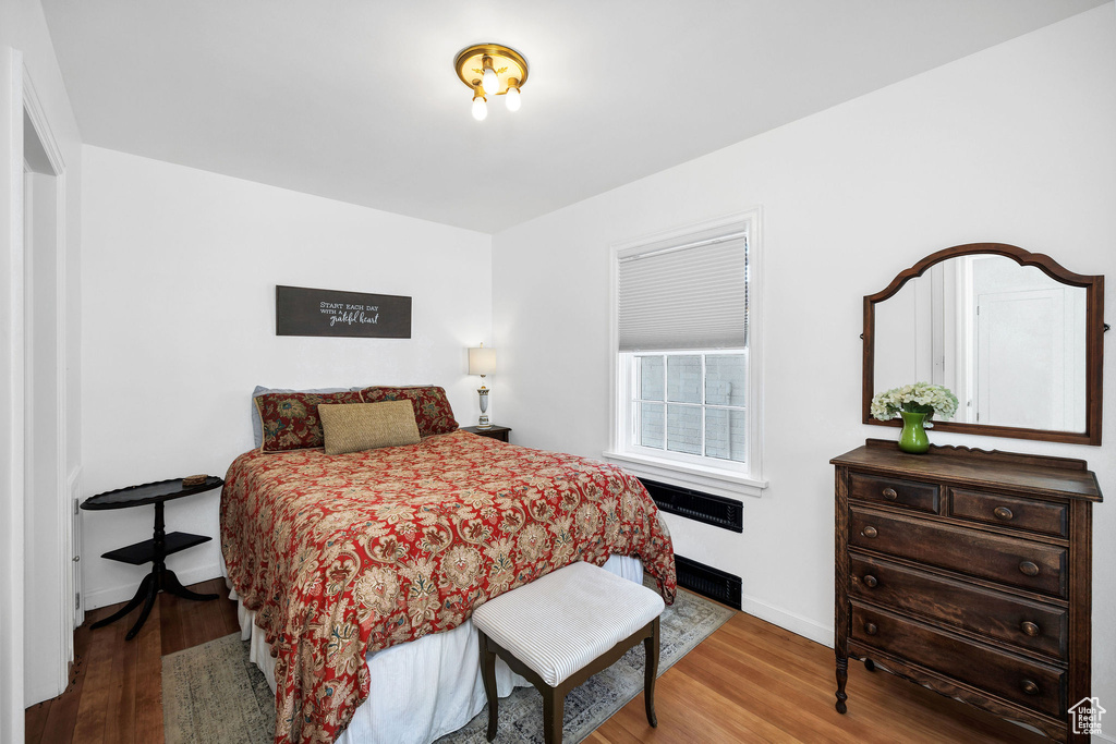 Bedroom with wood finished floors and baseboards