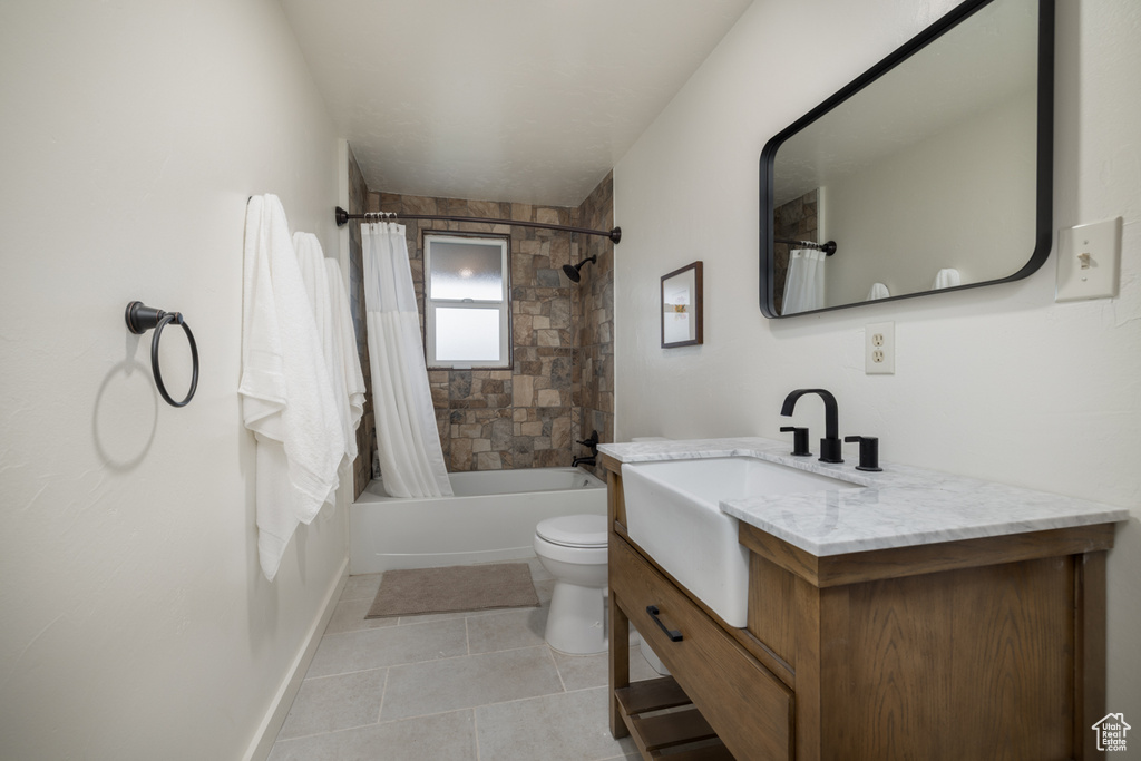 Full bath featuring tile patterned flooring, toilet, shower / bath combination with curtain, and vanity