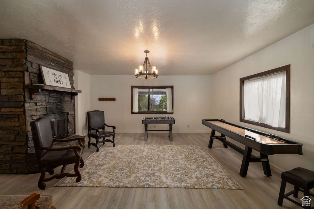 Sitting room featuring wood finished floors, a chandelier, and baseboards