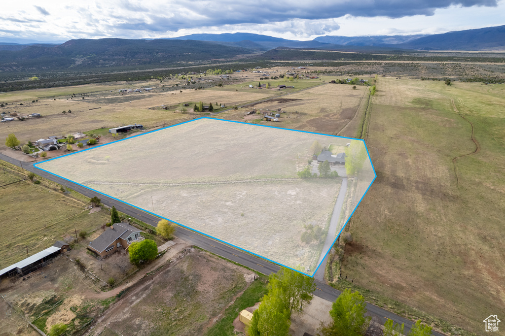 Aerial view of sparsely populated area featuring a mountainous background and property boundaries highlighted