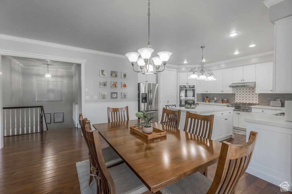 Dining space with a chandelier, ornamental molding, dark wood-style floors, and recessed lighting
