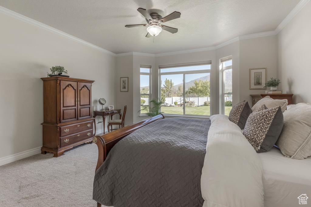 Bedroom featuring baseboards, ceiling fan, a water view, crown molding, and light carpet