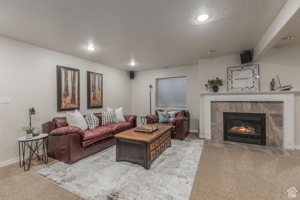 Living area featuring baseboards, light carpet, a fireplace, and recessed lighting