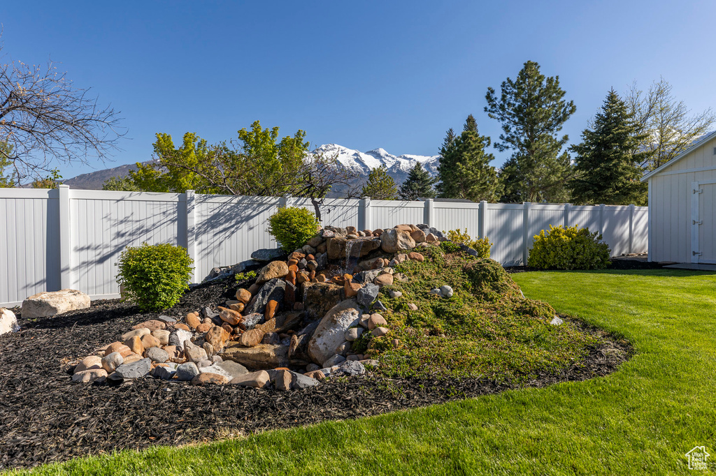 View of yard with a storage shed, a mountain view, an outdoor structure, and a fenced backyard