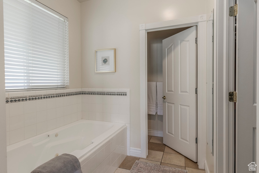 Bathroom with baseboards, tile patterned floors, and a garden tub
