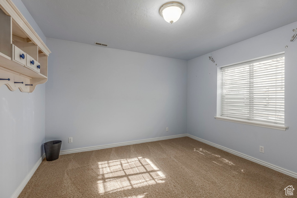 Empty room with carpet, baseboards, and visible vents