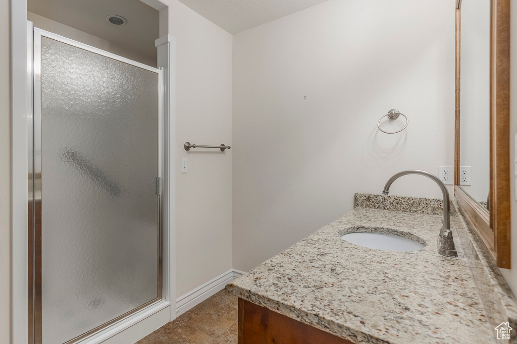 Bathroom with vanity, baseboards, and a shower stall