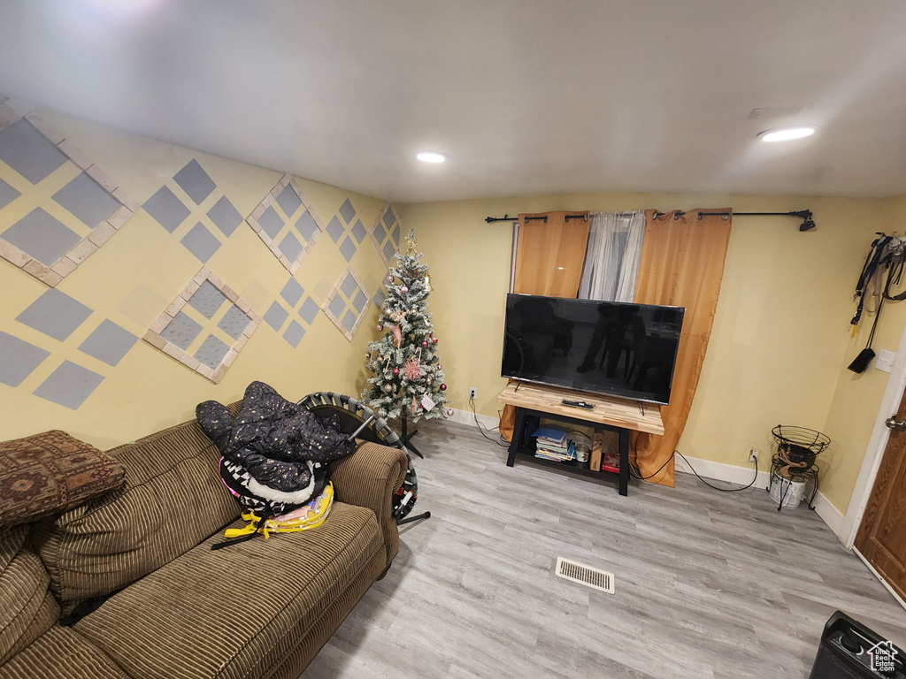 Living area featuring light wood finished floors, visible vents, baseboards, and recessed lighting