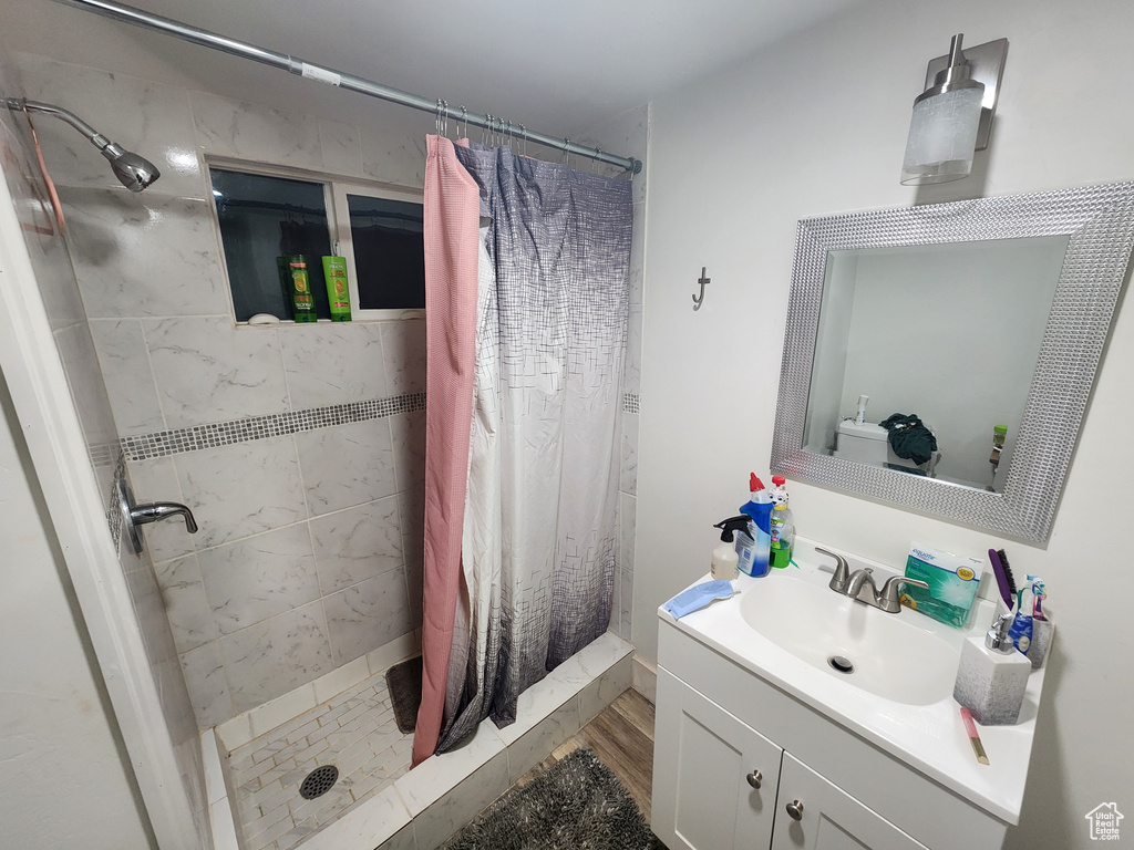 Full bath with a shower stall, vanity, and wood finished floors