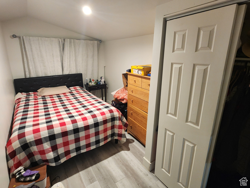 Bedroom with vaulted ceiling and wood finished floors