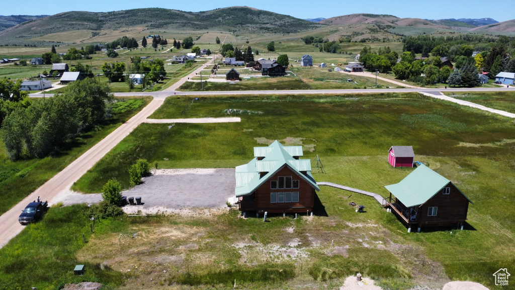 Aerial view of property and surrounding area with a mountain backdrop and rural landscape