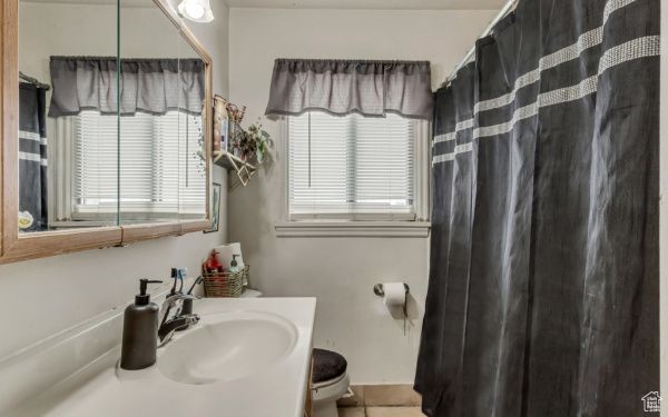Full bath featuring toilet, tile patterned flooring, vanity, and a shower with shower curtain