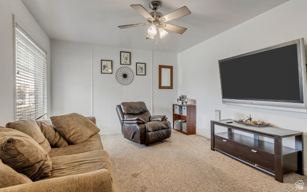 Living area featuring a ceiling fan and carpet floors