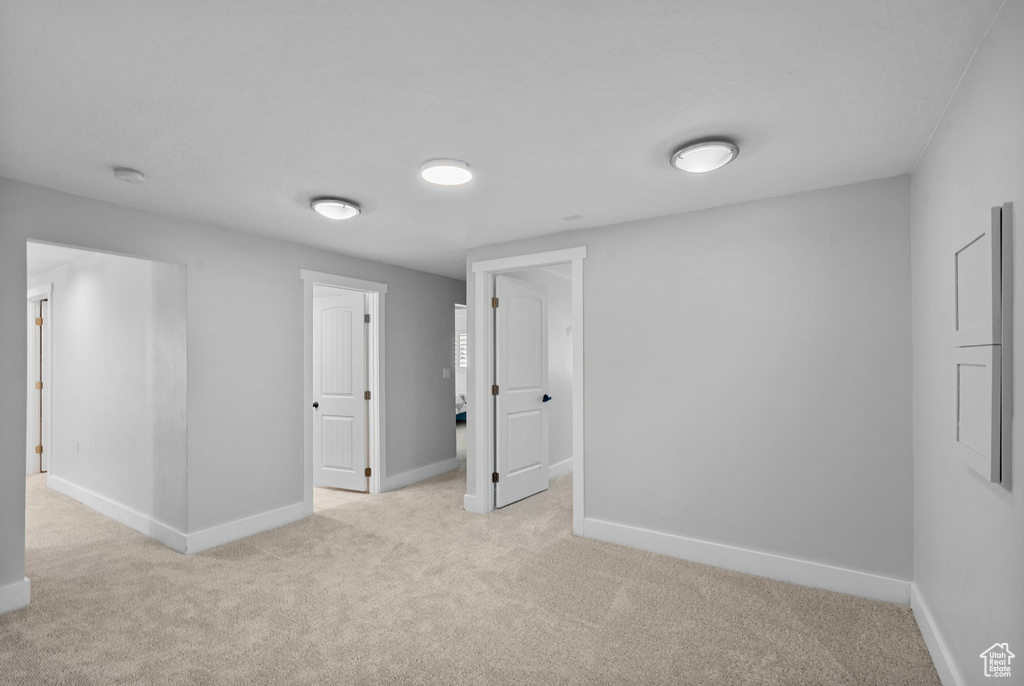 Spare room featuring light colored carpet and baseboards
