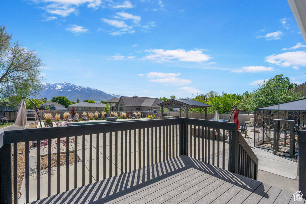 Wooden deck with a gazebo, fence, a mountain view, and a residential view