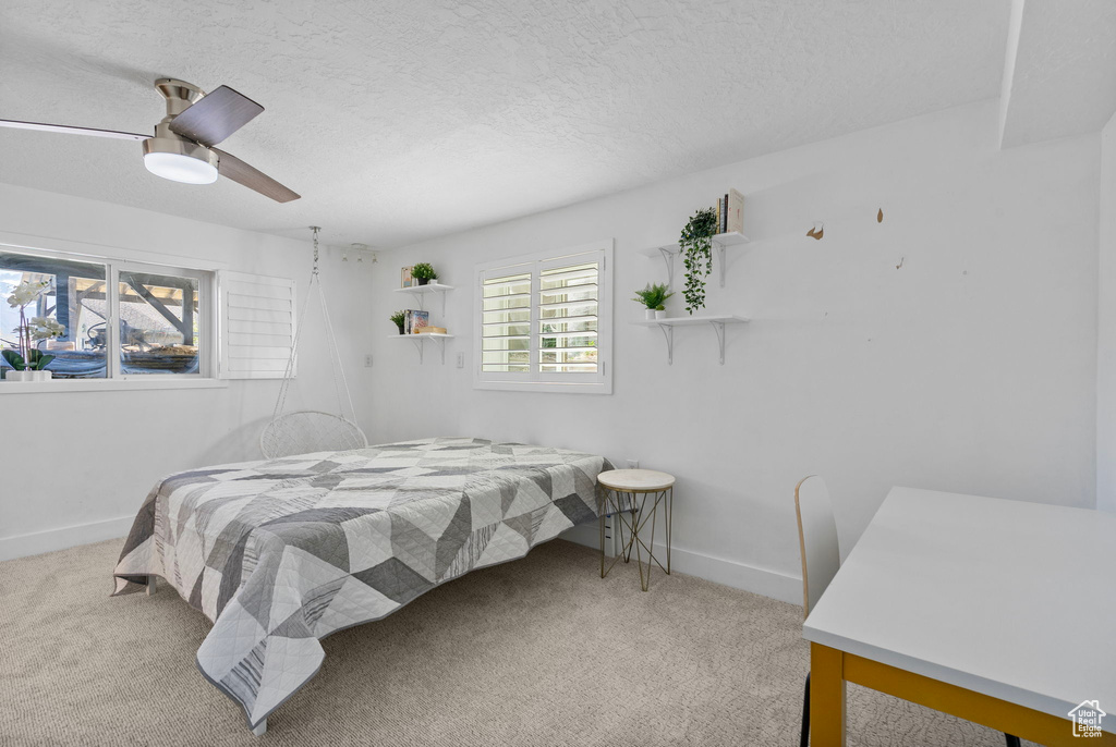 Bedroom featuring carpet, a textured ceiling, and baseboards