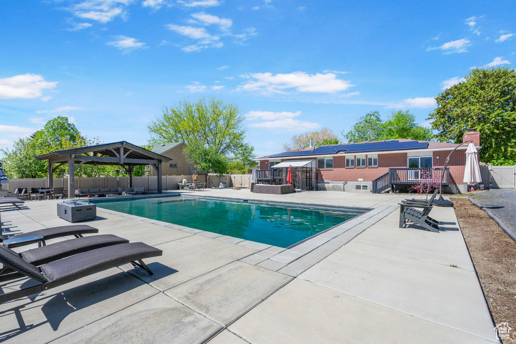 View of pool with a gazebo, a patio, a fenced backyard, a wooden deck, and a fenced in pool