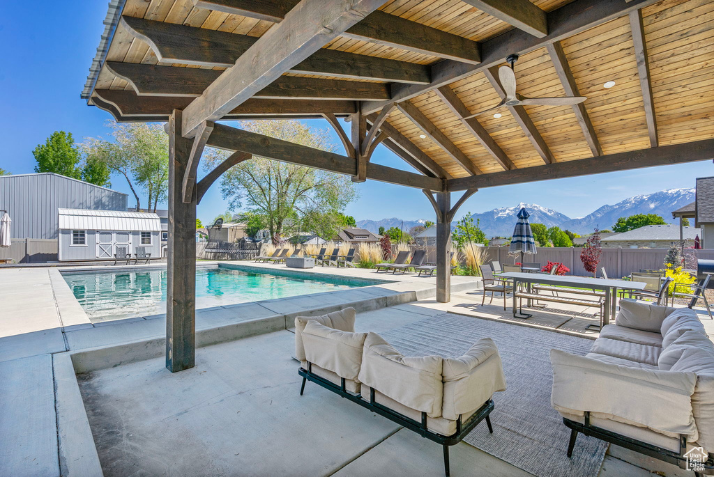 View of patio / terrace featuring an outdoor hangout area, a mountain view, fence, and a fenced in pool