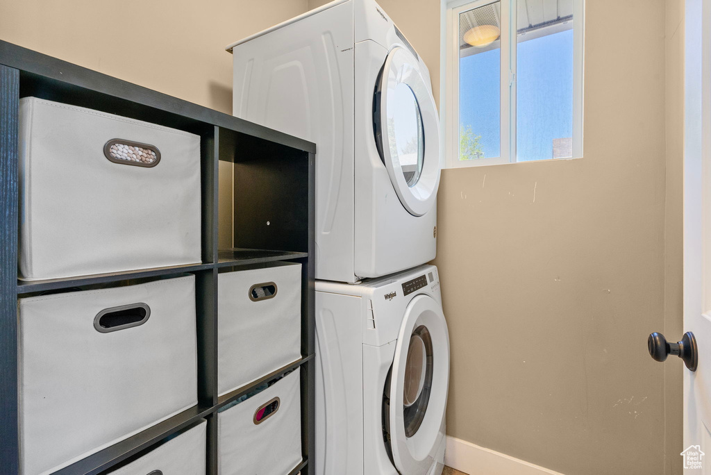 Clothes washing area with stacked washer and dryer and laundry area