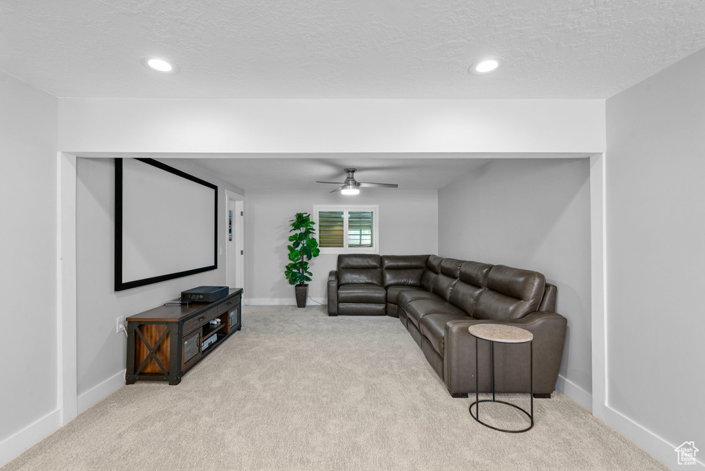 Carpeted living area with baseboards, recessed lighting, ceiling fan, and a textured ceiling