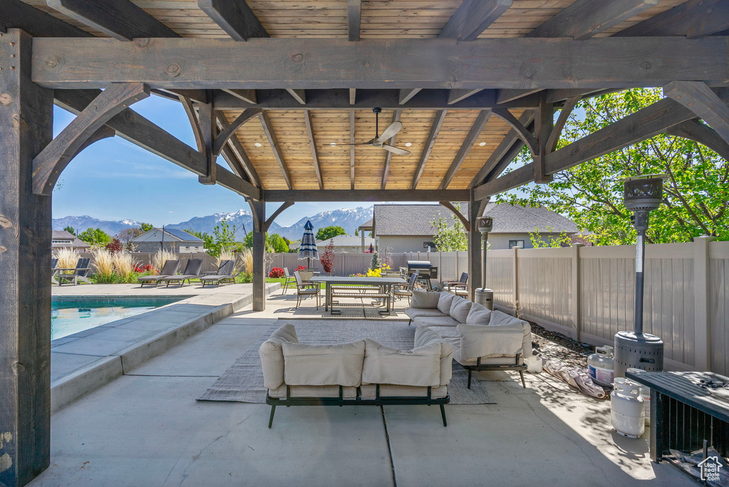 View of patio with a mountain view, outdoor dining space, outdoor lounge area, ceiling fan, and a fenced backyard