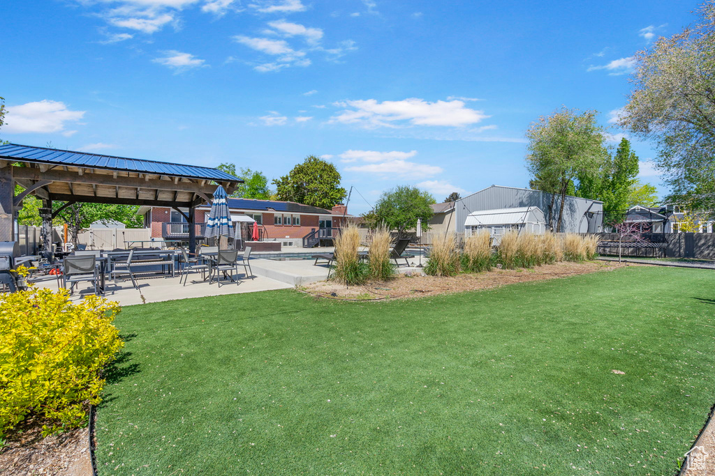 View of yard featuring a gazebo, a patio area, fence, and a residential view