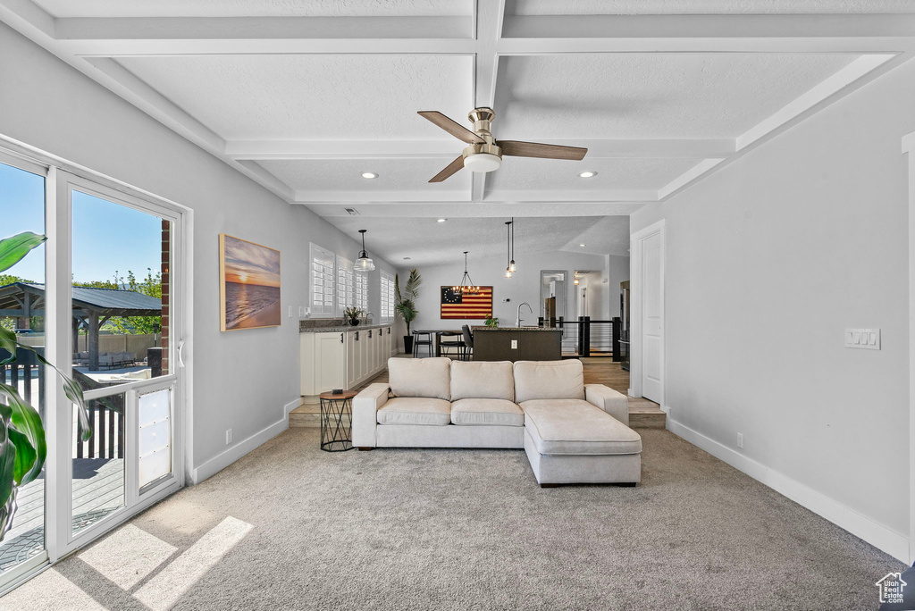 Living room with light colored carpet, baseboards, ceiling fan, and recessed lighting