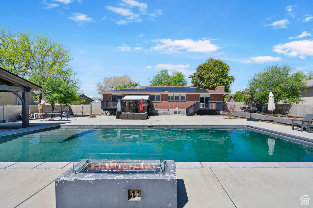 View of pool featuring an outdoor fire pit, a patio, a fenced in pool, and a fenced backyard