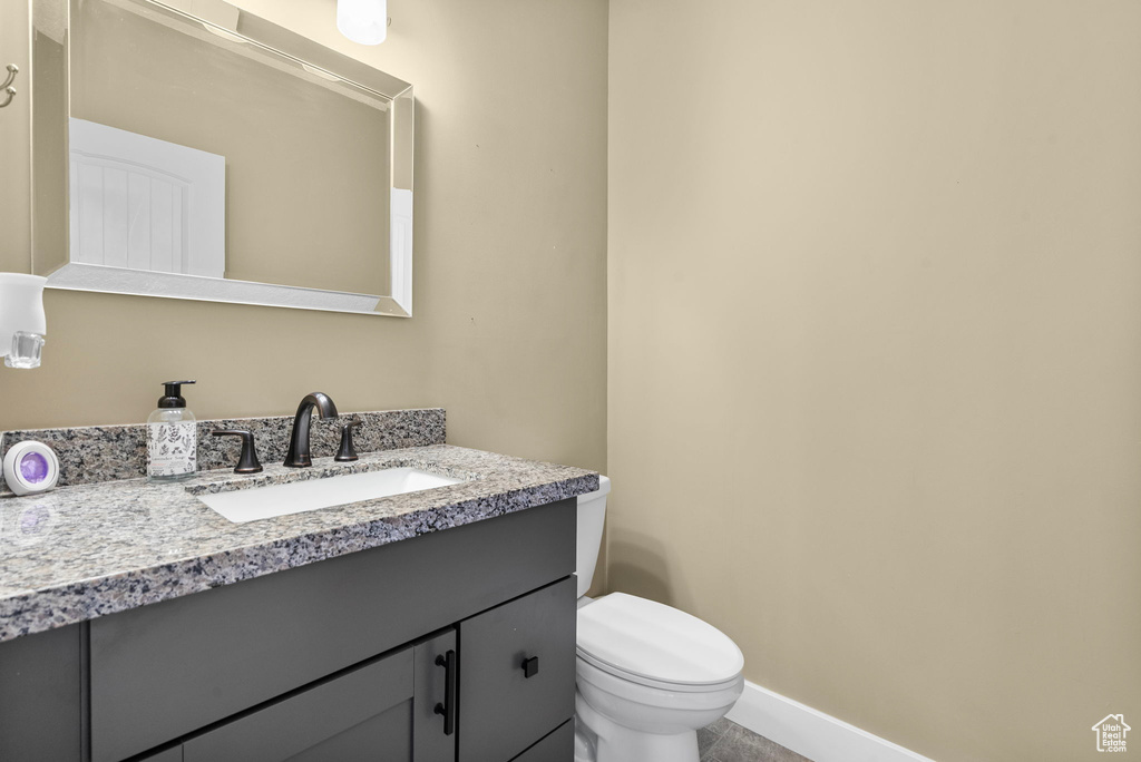 Bathroom featuring toilet, baseboards, and vanity