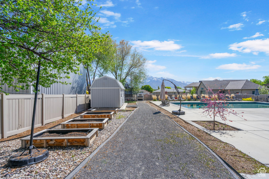 View of yard with an outdoor structure, a storage shed, a patio area, a garden, and a fenced backyard