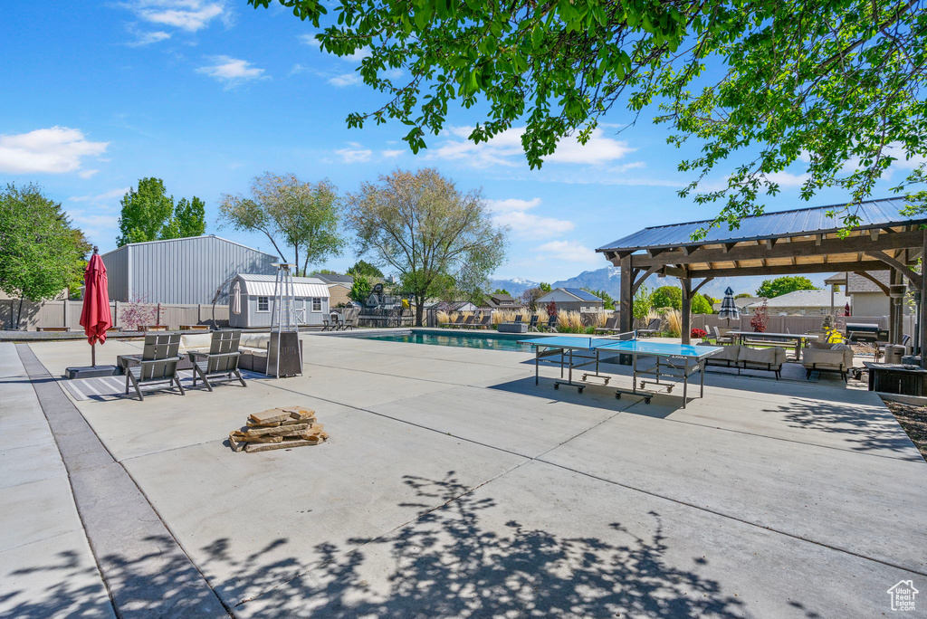 Pool featuring a patio area, fence, and a gazebo