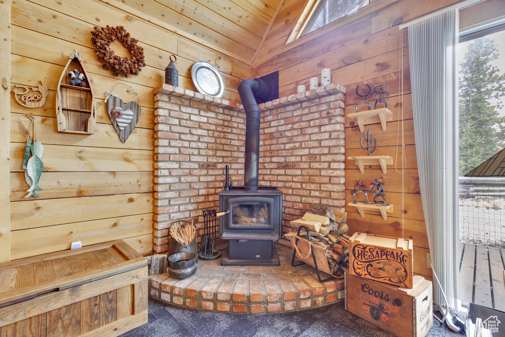 Interior details featuring a wood stove, carpet, and wooden walls