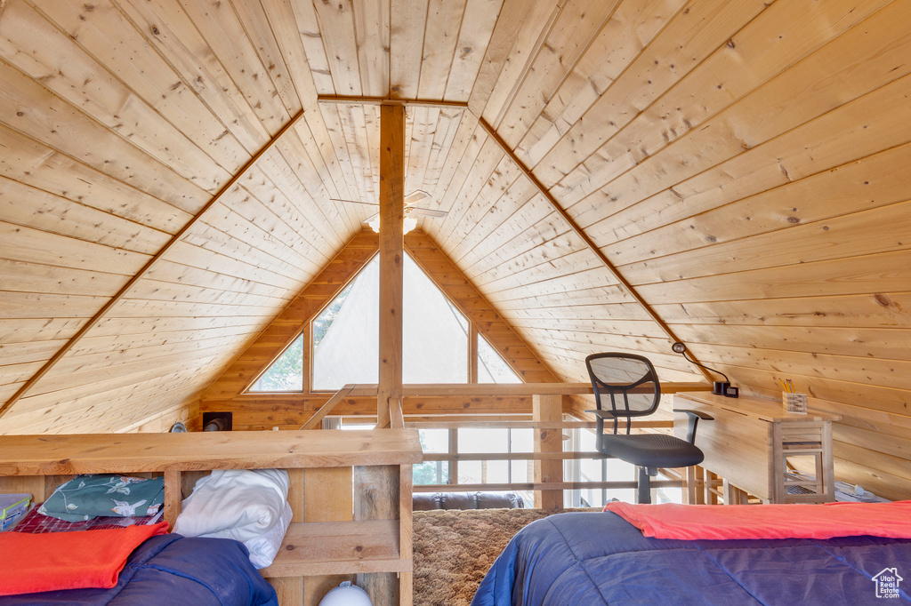 Bedroom with wooden ceiling, lofted ceiling, and wooden walls