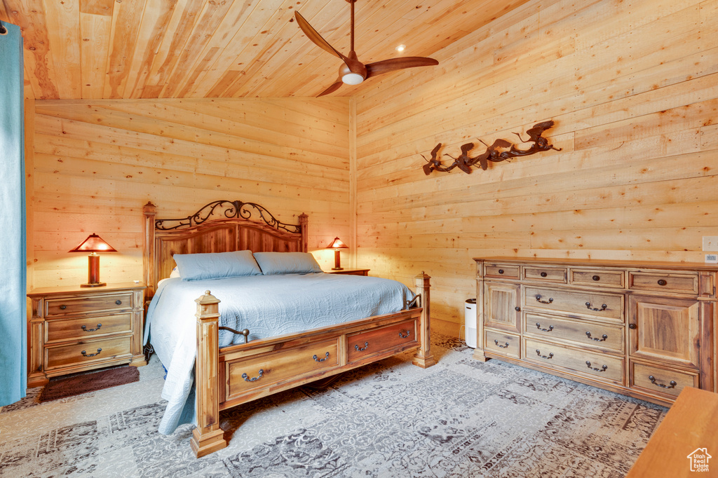 Bedroom featuring vaulted ceiling, ceiling fan, wood walls, and wood ceiling
