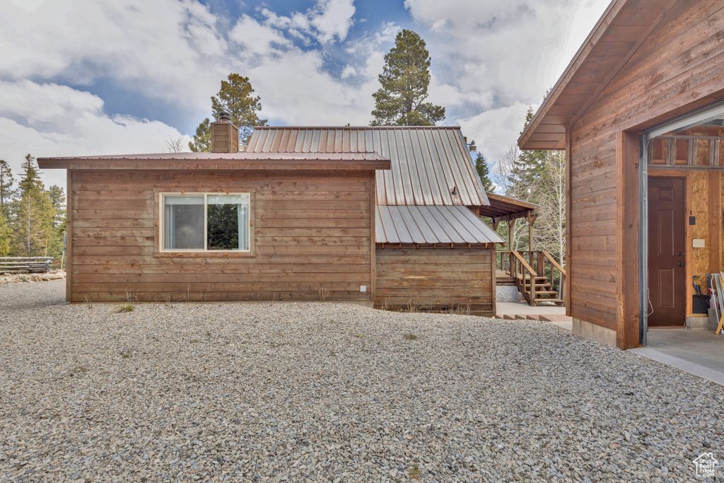 View of property exterior featuring metal roof and a chimney