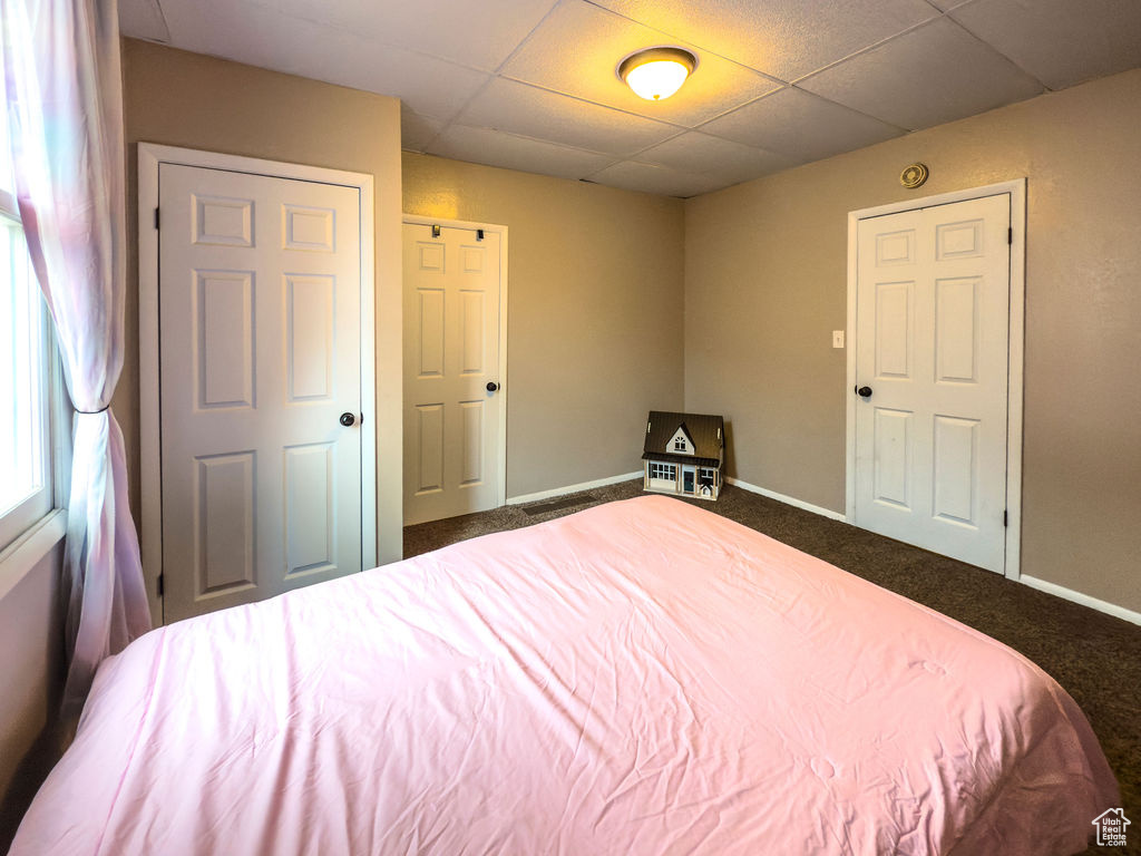 Bedroom with carpet flooring, baseboards, and a paneled ceiling